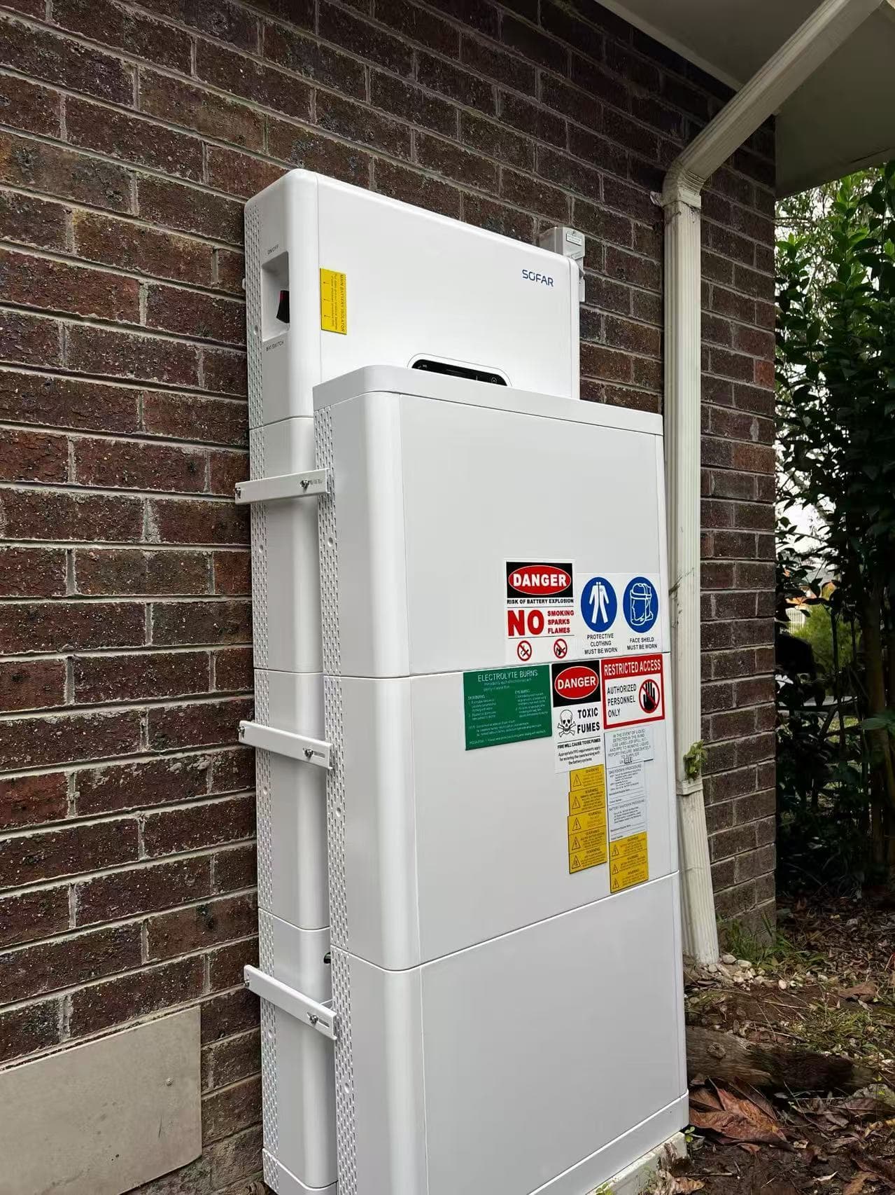SOFAR battery equipment installed beside an exterior brick wall